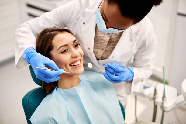 happy woman having her teeth checked during appointment at dental clinic.