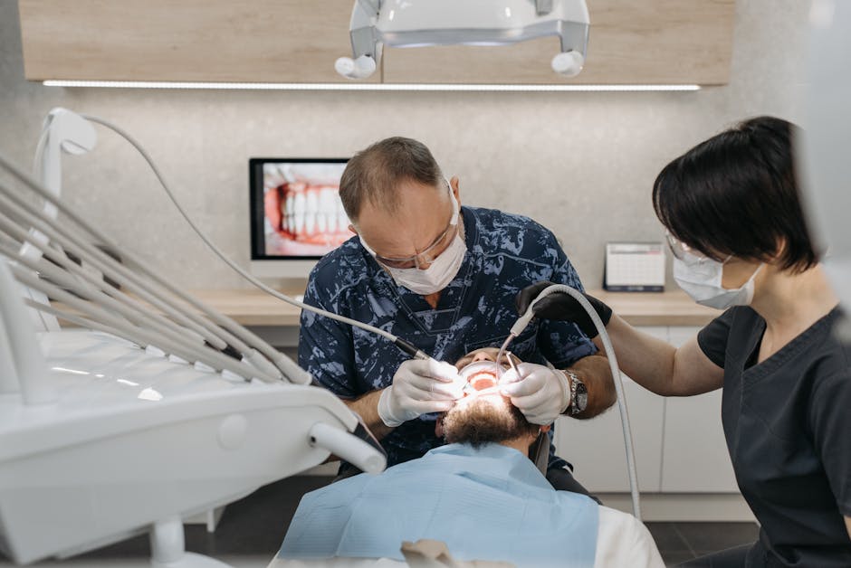 Dental Emergency Guide | What To Do Immediately Dentist and assistant performing a dental procedure on a patient in a modern clinic.
